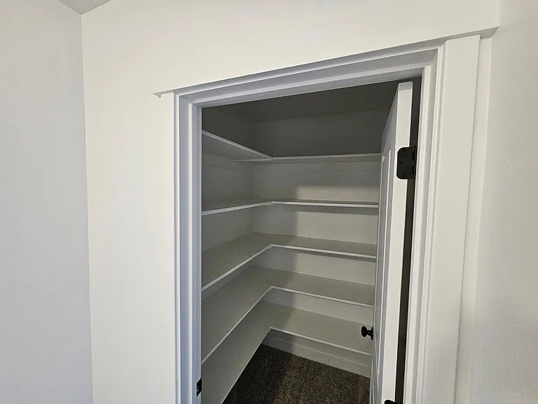 Upstairs storage closet with built-in shelves.