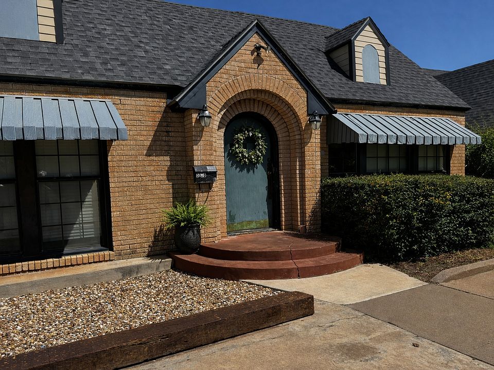 Front view of home with paved off street parking for 2 cars to the right of the front sidewalk