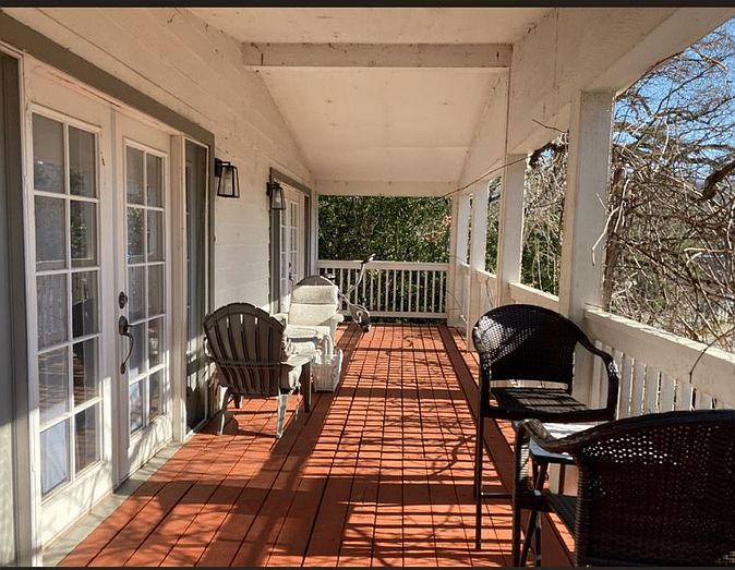 215_SF Covered Patio with Multiple Seating Areas, Stationary Bicycle, and Light Free Weights