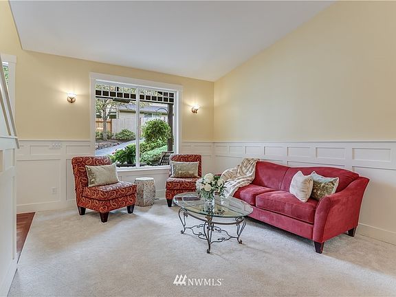 Once inside, step into the formal living room with vaulted ceilings, wainscoting, and plenty of light pouring in!