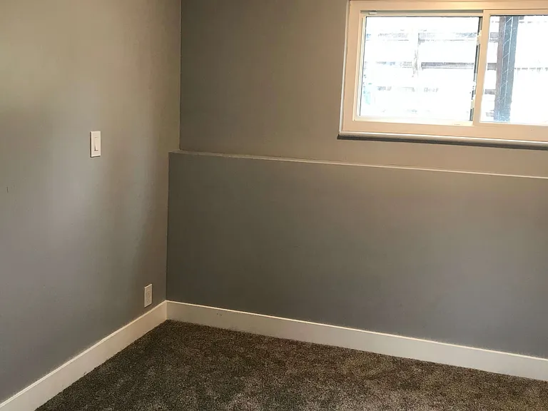 bedroom corner with light on and shutters open