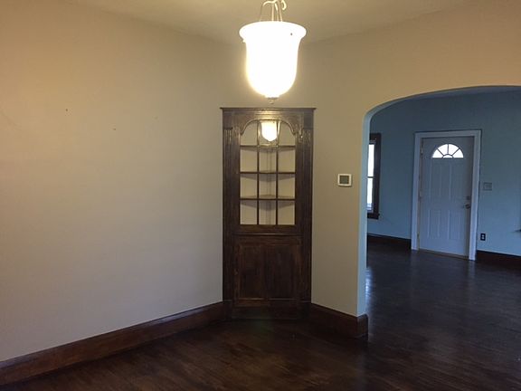Spacious dining room with corner cabinet and new chandelier.