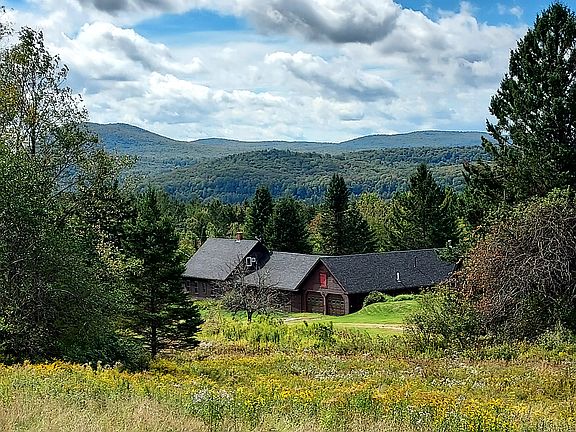View of property from field behind the house. There are 2 homes on this "L-shaped" property - the farmhouse, which has 2 stories and 4 bedrooms; and the 1 bedroom "mother in law" style apartment (listed here), which you enter through the garage.