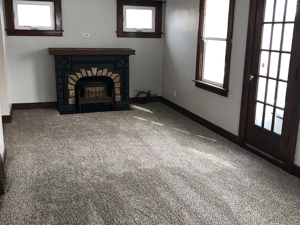 Living Room with new windows, original wood trim, decorative fireplace, new carpet and paint