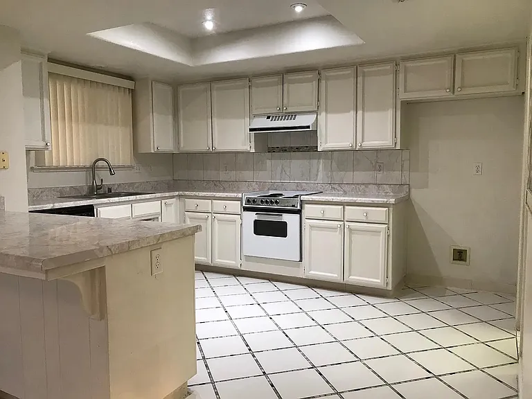 A well layout kitchen with gas stove, dishwasher, garbage disposal.