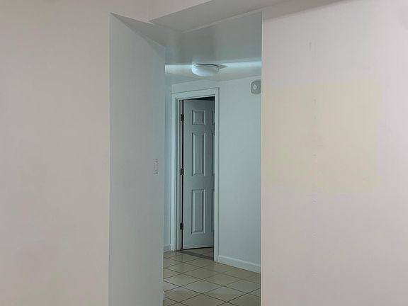 Hallway from kitchen/dining area leading to bathroom and bedrooms