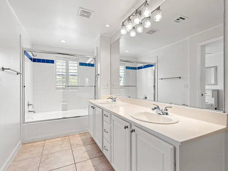 Dual sinks, WC, large shower/tub combo with upgraded glass door.