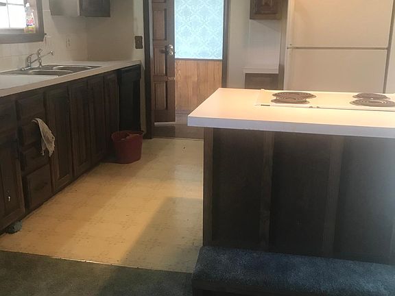Kitchen showing range, hood, and refrigerator in the right side