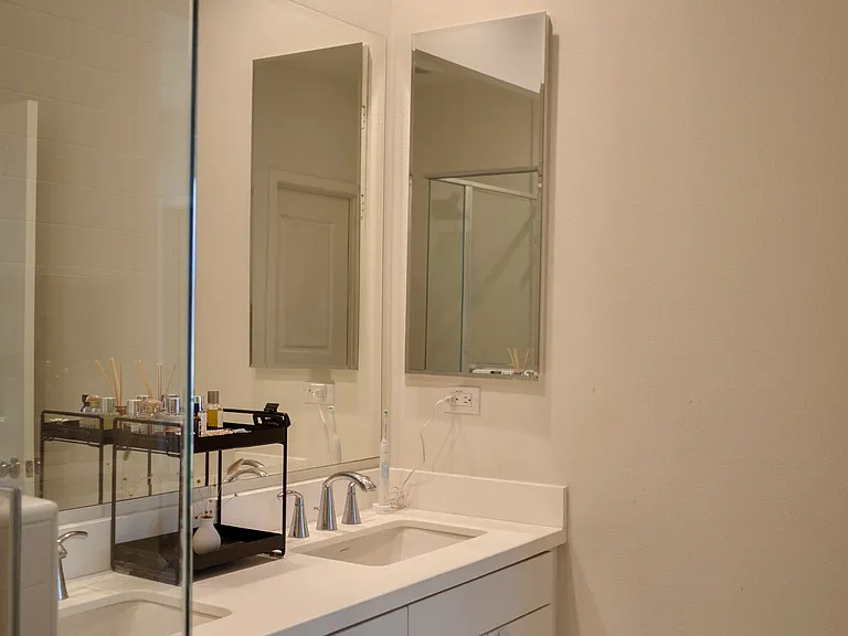 Primary Bathroom: Features a spacious double-sink vanity with a large overhead mirror and a convenient, built-in medicine cabinet.
