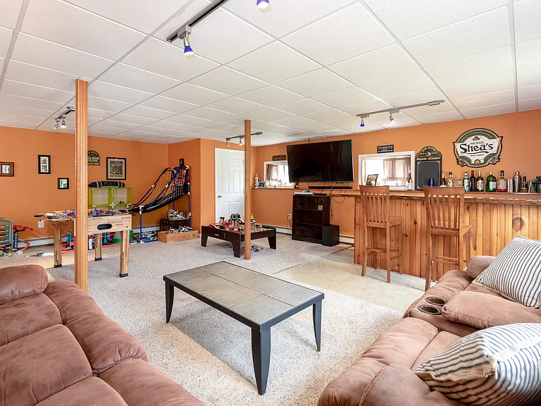 Finished basement with storage closet and unfinished area next to it. Bar is no longer there and paint is no longer orange