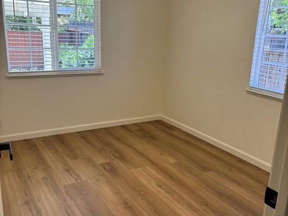 One view of Bedroom #3. entirely renovated with all new flooring, paint, window covering, doors and light features.