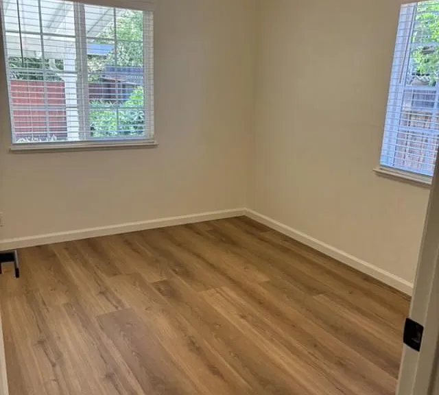 One view of Bedroom #3. entirely renovated with all new flooring, paint, window covering, doors and light features.