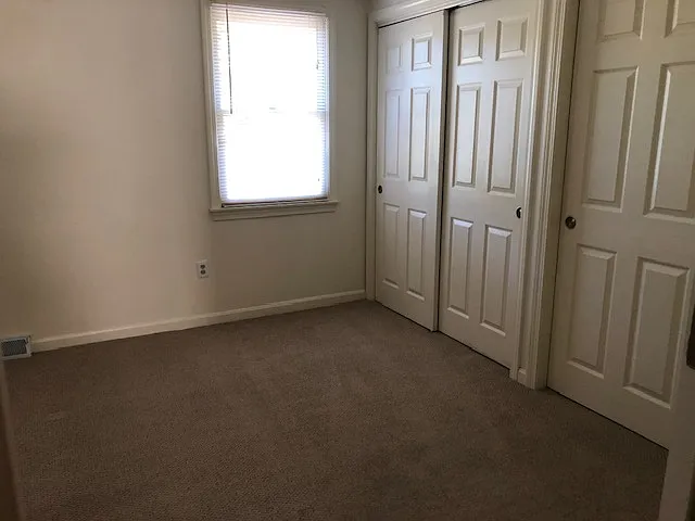 Bright guest bedroom with 2 large windows and a full length closet offering generous storage.