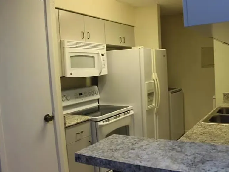 Functional kitchen with a full appliance set, ample upper cabinetry, and long counters with a breakfast bar for prep and meal