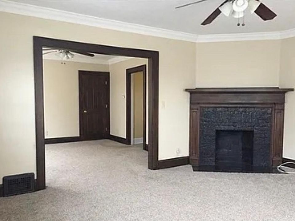 The color scheme leads into the dinning room. The charcoal black fireplace is charming to say the least. The ceiling fans match the beautiful hardwood trim.
