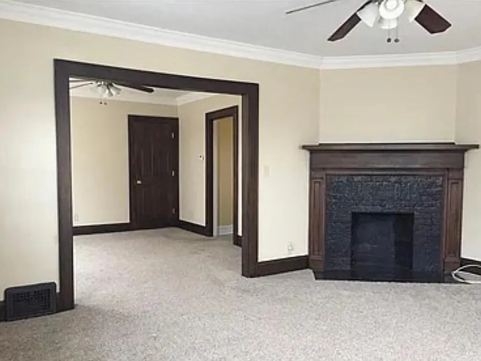 The color scheme leads into the dinning room. The charcoal black fireplace is charming to say the least. The ceiling fans match the beautiful hardwood trim.