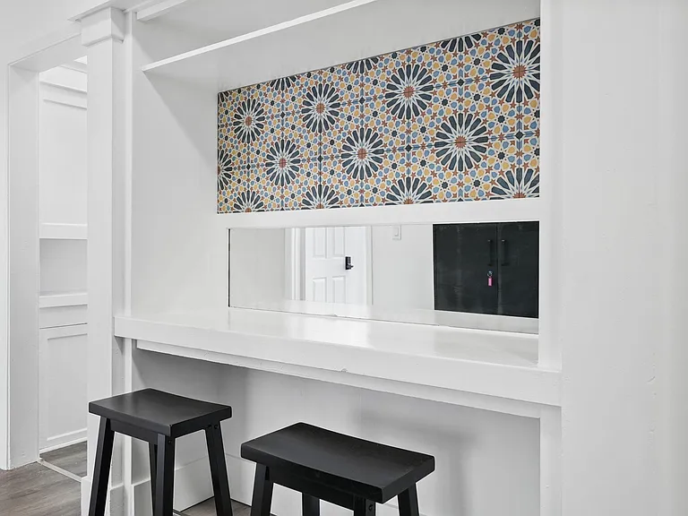 Built-in pass-through breakfast bar with counter seating and decorative tile accent, ideal for casual meals or workspace.