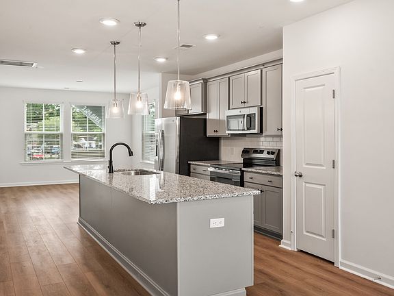 Kitchen in Hayden Floorplan with large island and lots of natural light at Clear Springs Townhomes