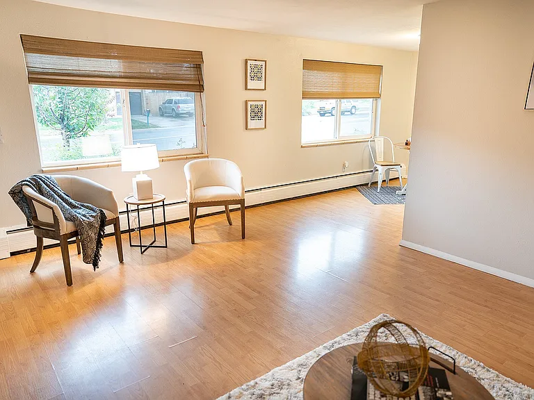 Bright, inviting living space with large windows, modern decor, and warm wooden flooring, perfect for relaxation and entertaining.