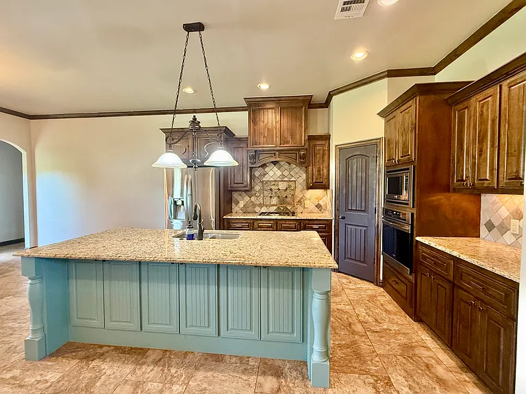 Pantry off to the right corner. Stainless steel oven and microwave. Lots of storage in the kitchen island on both sides.