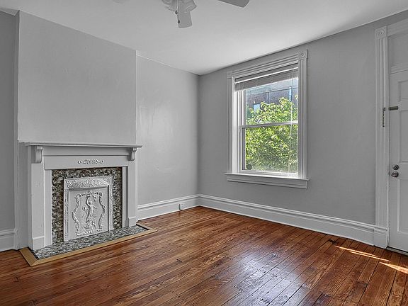 The Family Room - salvaged hardwood floors bathed in natural light, venetian blinds