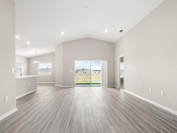 This home features a sunny, open living area with volume ceilings - Sophia by Highland Homes