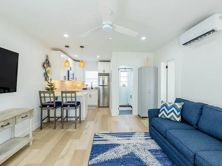Open-concept living area with a breakfast bar, stainless-steel fridge, and comfortable seating for relaxing or entertaining.