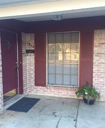 Very decent sized front porch. Brick exterior with burghandy trim and door.
