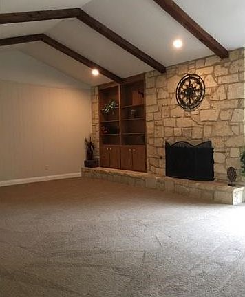 Spacious living room with gas starter fireplace and wonderful wood beams!  Love the built ins as well!