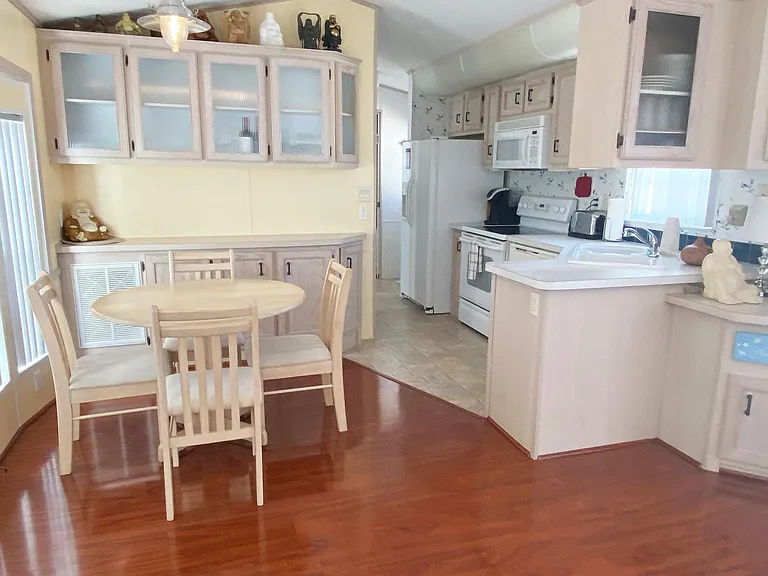 Main area comes furnished with dining table, built in buffet cabinets, sofa and glass book (or display) case.