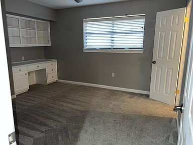 Bedroom with built-in desk and shelving and walk-in closet