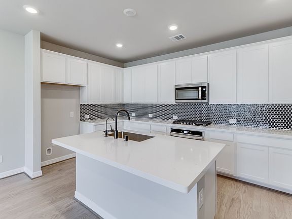Kitchen with white cabinets and a modern tile backsplash