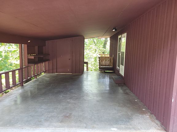 Car port area / small storage area near back of car port on left.