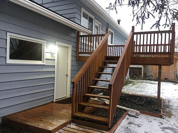 back of the house deck with stairs and back of garage door and deck