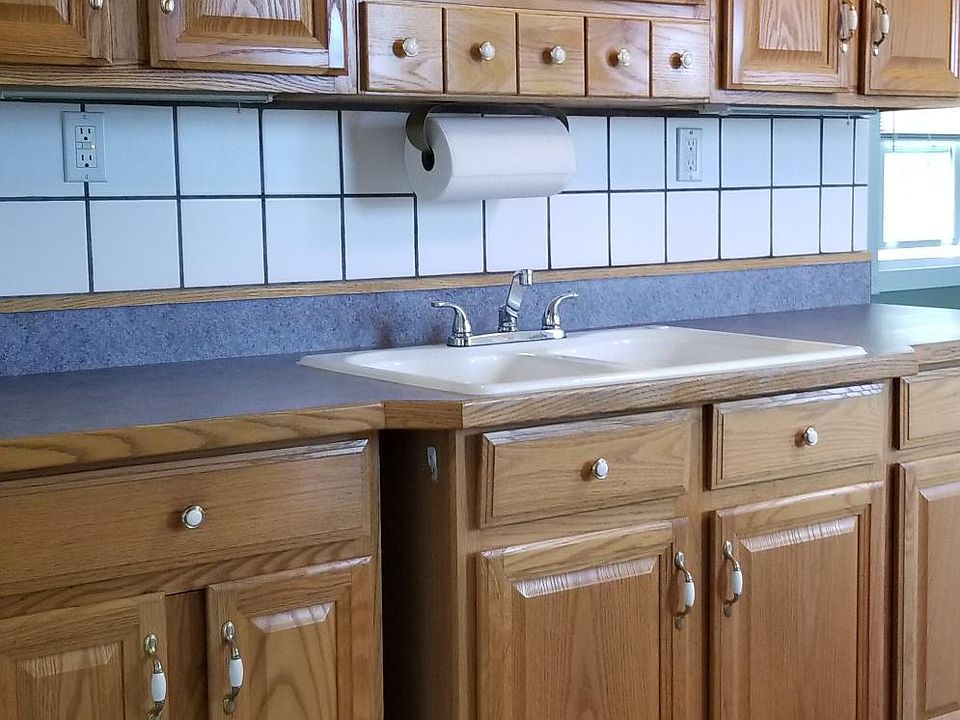 Red oak cabinets, white porcelain double sinks, tiled wall, GFC outlets