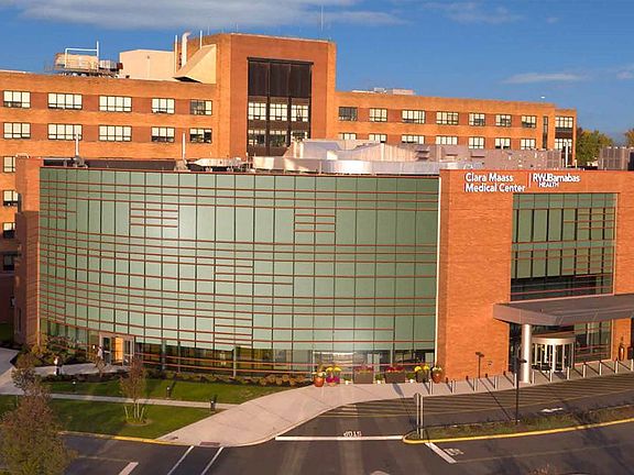 Large multi-story brick building with a covered main entrance and landscaped walkway.