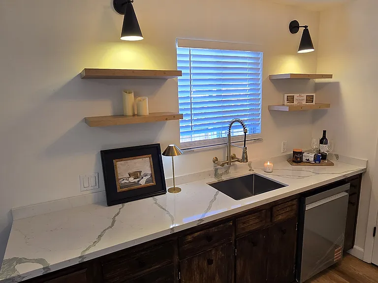 Kitchen with open shelving and custom sconces.