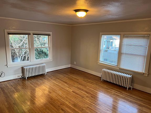 Living room with garden views and wood floors.