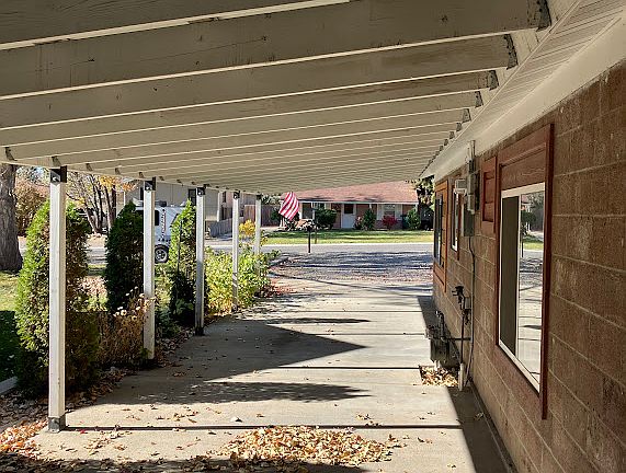 1 car is stored in the back of the port. Front car space reserved for the tenant(s). Garden space for tenants between the cedars.