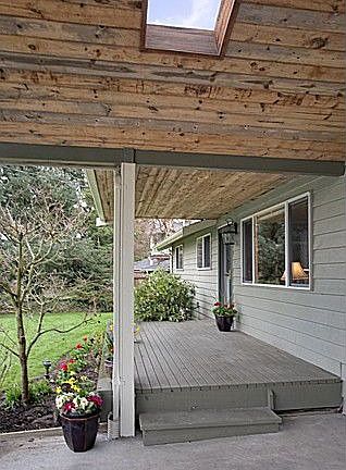 Front entry is just one step to wide wooden porch. Vaulted carport has T-n-G pine and skylight!