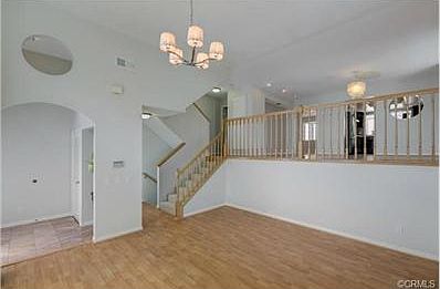 The living room features a high ceiling that gives the unit a br