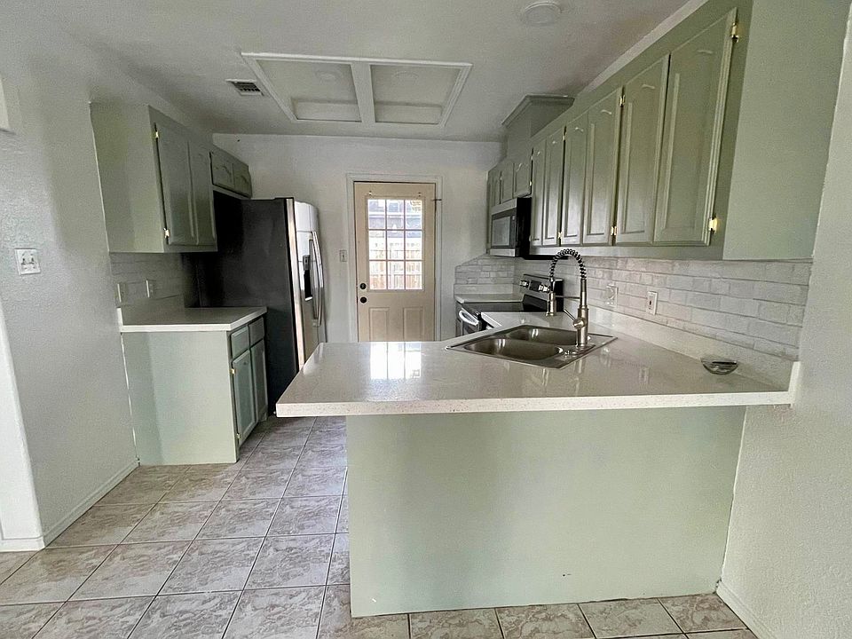 Kitchen newly renovated. Includes refrigerator, microwave, stove and oven. Door leads to backyard.