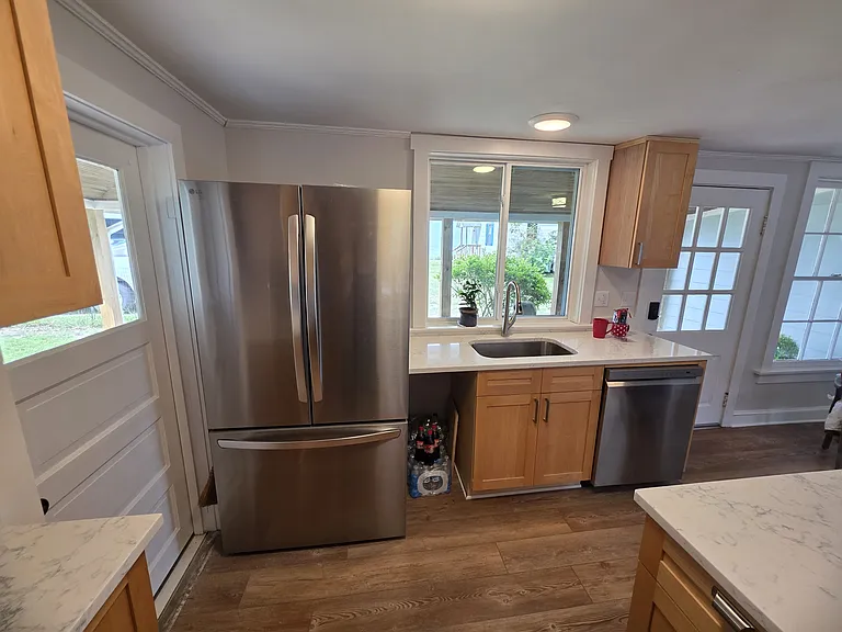Updated kitchen looking out toward wraparound porch. Kitchen includes new stainless steel appliances.