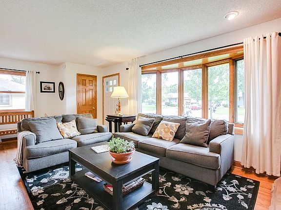 Another angle of the living room showcasing the natural light from the large bay window.