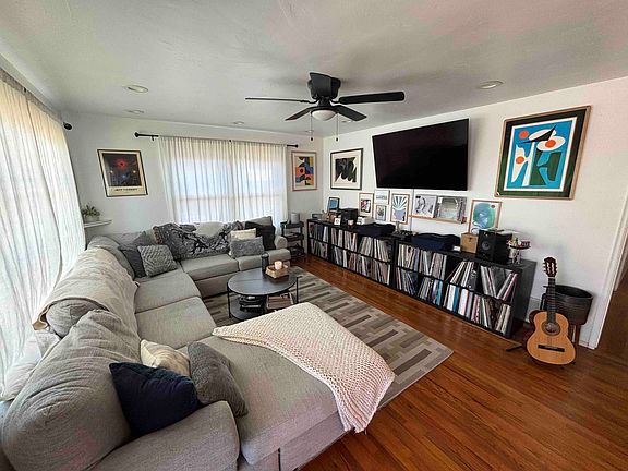 Open and vibrant living room with plenty of natural light. 65" mounted smart TV