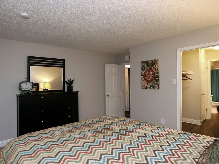 Bedroom with natural light and neutral color palette with private access to a walk-through closet and bathroom.