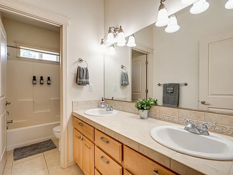 Featuring double sink and separate space for the toilet and shower.