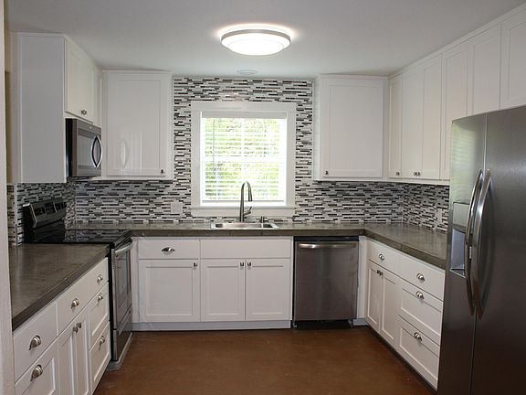 Spacious Kitchen with custom cabinets, concrete counter tops, ceramic tile backsplash and all new appliances.