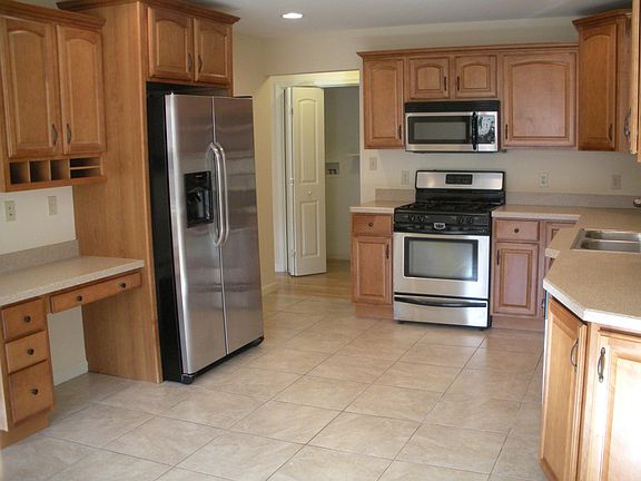 Kitchen with laundry room in hallway behind bifold doors at 