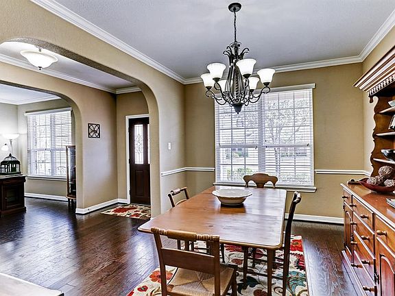 Formal dining and study with crown molding, chair railings and views of the tree-lined street.